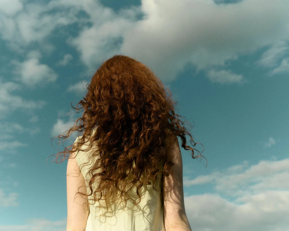 Girl looking into a sky full of clouds